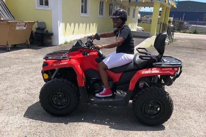 A person riding a red ATV on a paved surface. 5