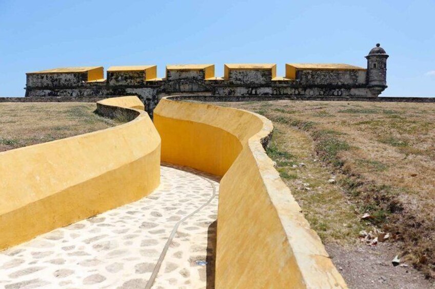 A yellow-walled fortification with a clear sky. 2
