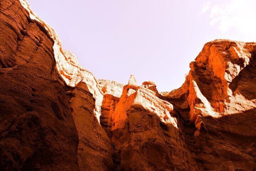 A canyon with reddish-brown rock formations and a clear sky. 3