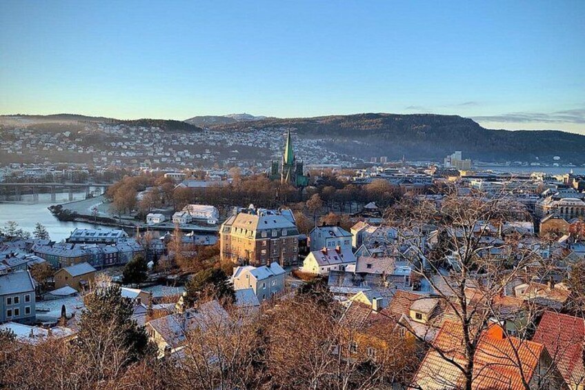 A cityscape with a prominent church spire, a river, and snow-covered buildings. 2