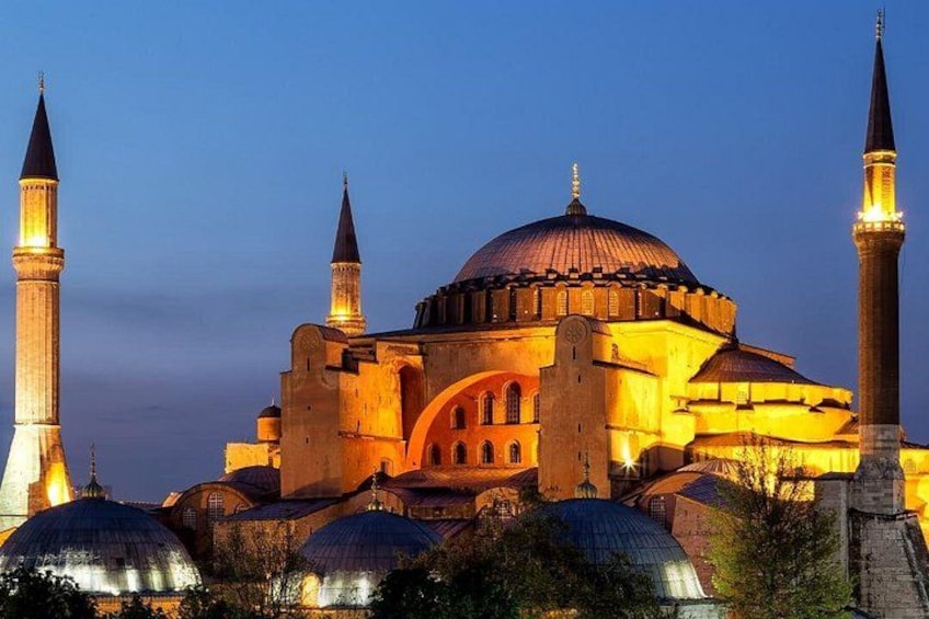 A grand mosque with multiple domes and minarets, illuminated at dusk. 5