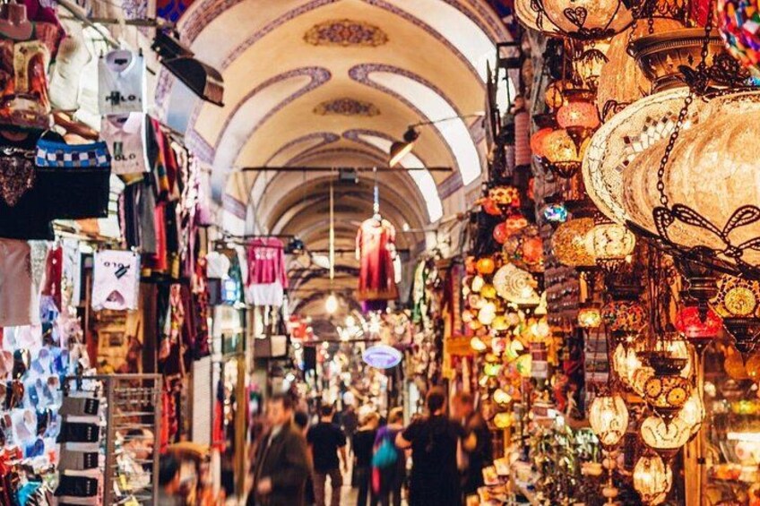 A bustling indoor market with various stalls selling textiles and decorative items. 4