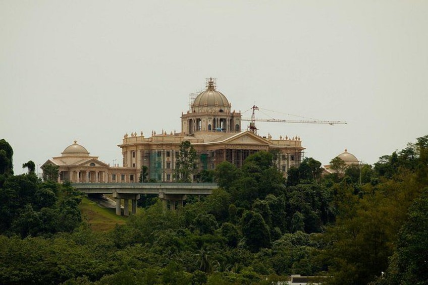 A large, historic building with a dome and construction crane, surrounded by lush greenery. 2
