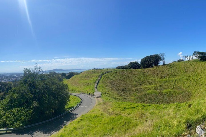 A winding road through a hilly landscape with trees and a clear sky. 4