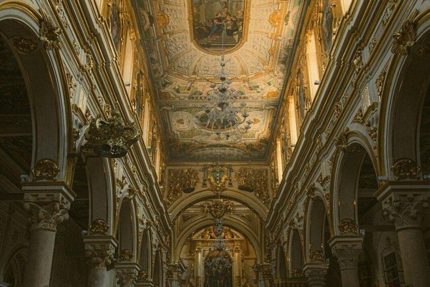 Un interior ornamentado con techo alto, frescos detallados y columnas clásicas. 4