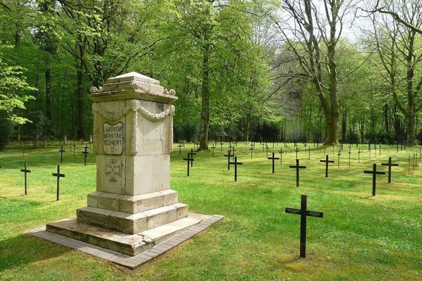 Ein Friedhof mit einem zentralen Denkmal, umgeben von Kreuzen. 4