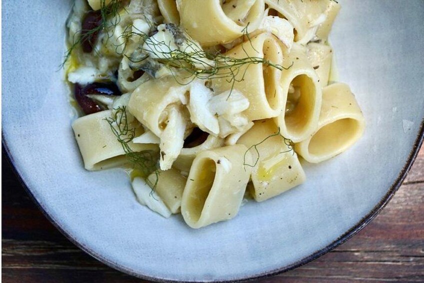 Un plato de pasta con salsa cremosa, adornado con hierbas. 2