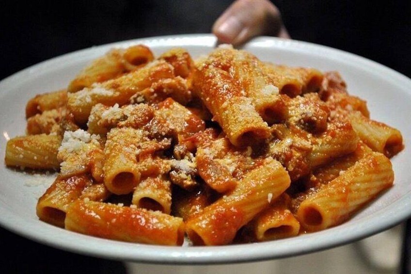 Un plato de pasta con salsa de tomate y queso rallado. 3