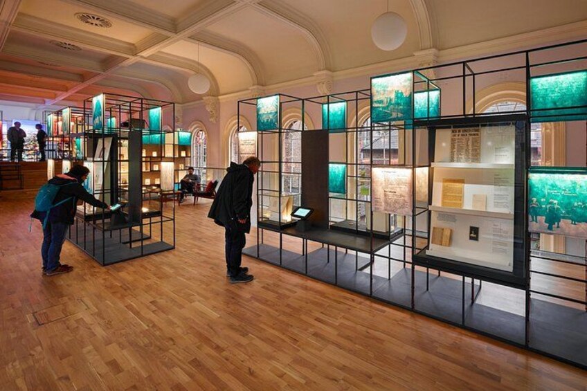 An indoor exhibition with glass display cases and wooden flooring. 5