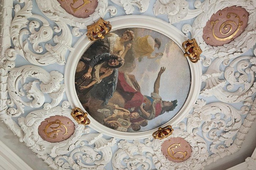 A ceiling with ornate carvings and a central circular painting. 5