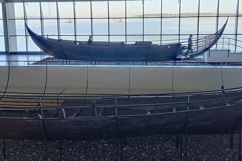 A museum exhibit with a large boat model and a smaller boat model on display. 4