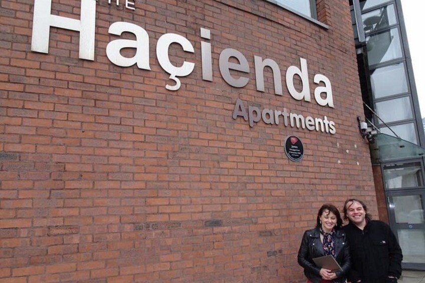 Een gebouw van baksteen met het bord 'Haçienda Apartments' en een plaquette. 1