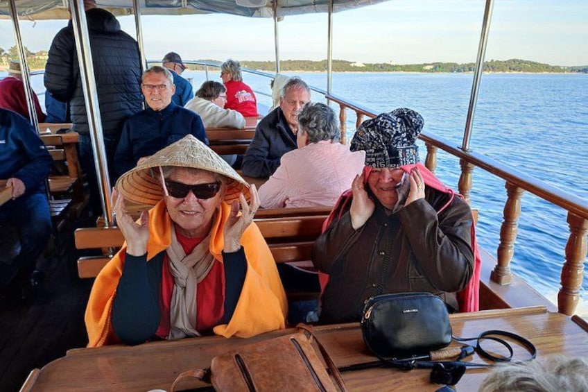 A boat with people seated, a wooden table, and a bag on the table. 3