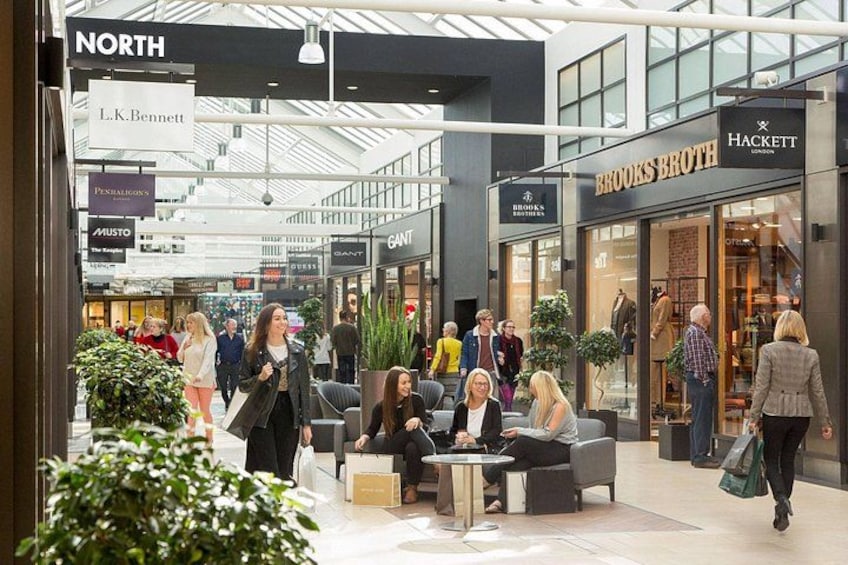 A shopping mall interior with stores like North, L.K. Bennett, Penhaligon's, Musto, Ganti, Brooks Brothers, and Hackett. 5