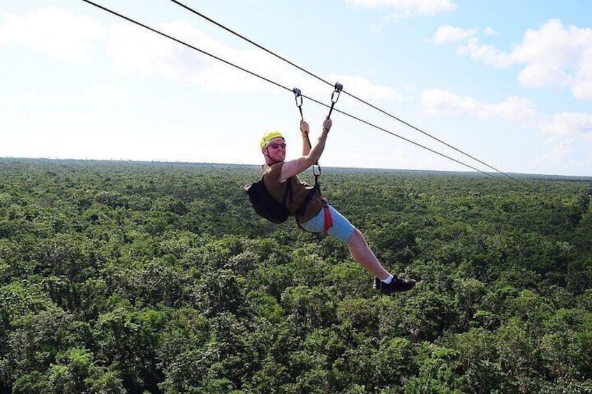 A person zip-lining through a dense forest canopy. 3