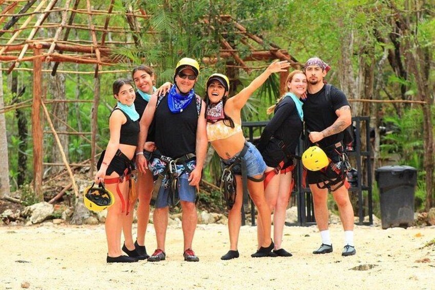 A group of people in outdoor gear, possibly on a hiking or adventure trip, with a natural, forested background. 3