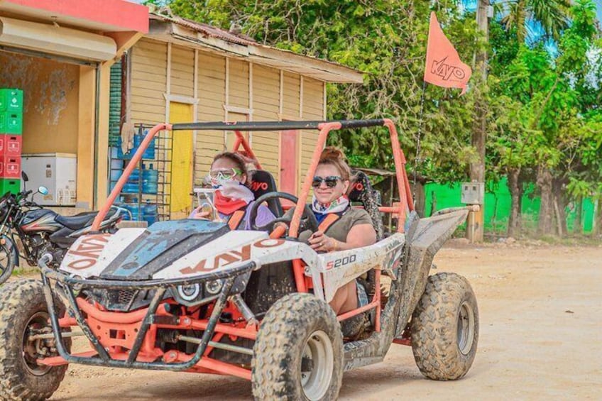 En rød ATV med '200' og 'MOTO' på siden, parkeret foran en bygning med et flag. 3