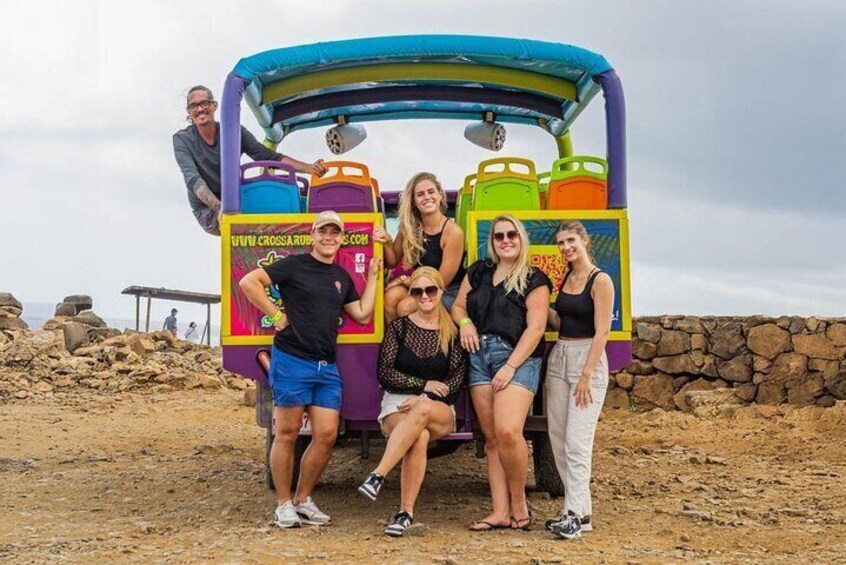 A group of people posing in front of a colorful inflatable structure with a website URL on it. 1