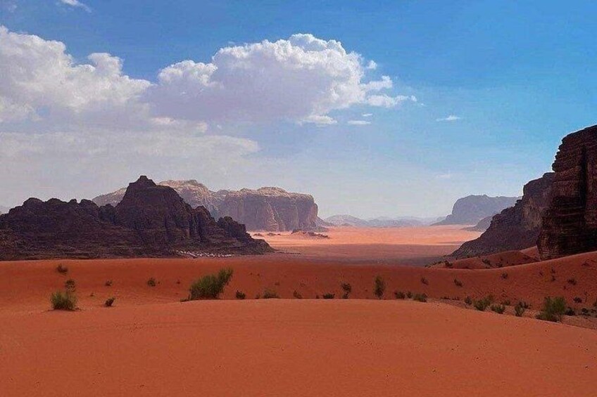 A desert landscape with sand dunes and rocky formations. 5