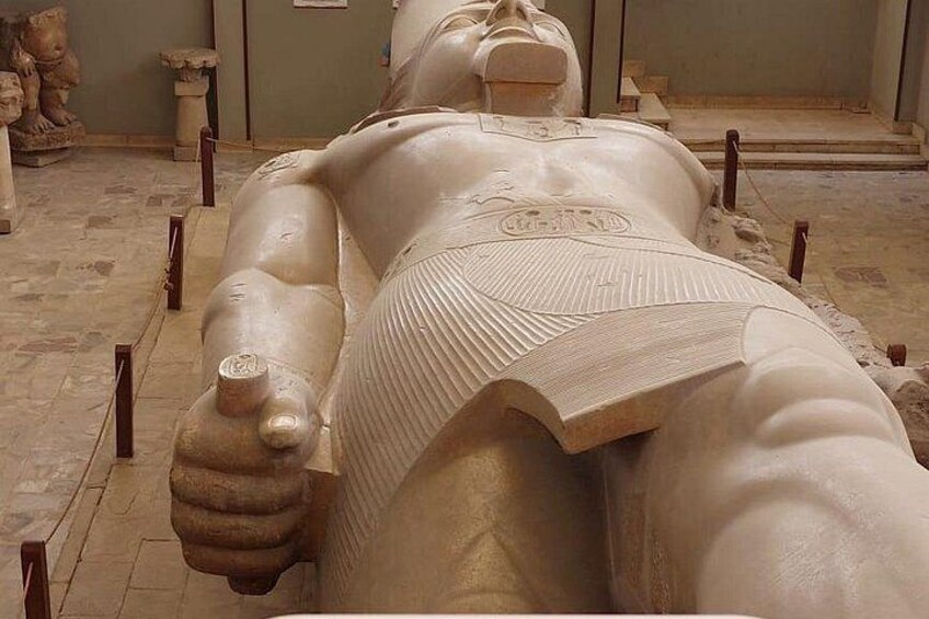 A large, reclining statue of a pharaoh in a museum. 5