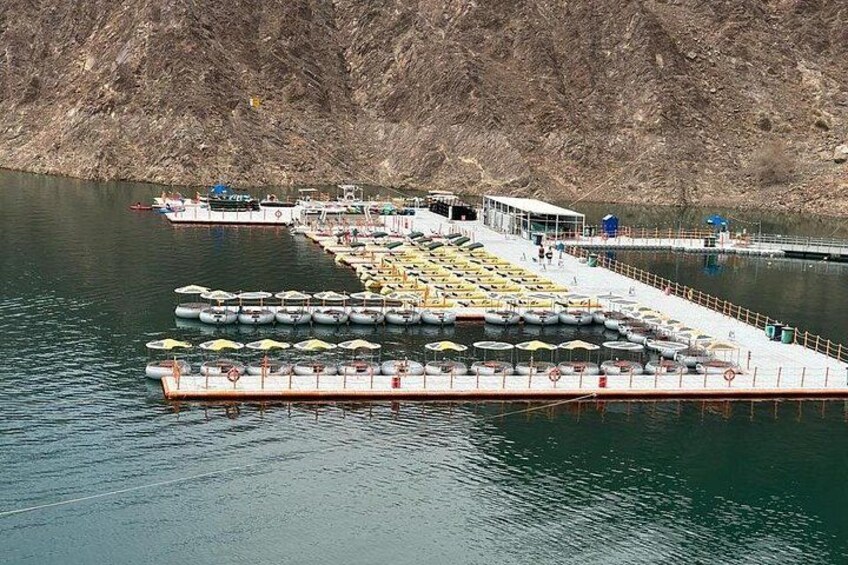 Un quai où sont amarrés plusieurs bateaux, et une côte rocheuse. 3