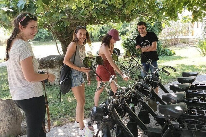 A group of people around stationary bikes in an outdoor setting. 2