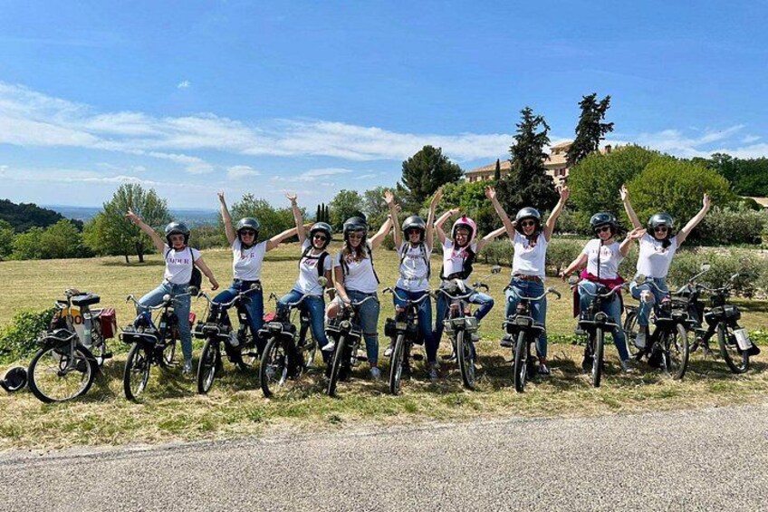 A group of people on bicycles in an outdoor setting with trees and a clear sky. 5