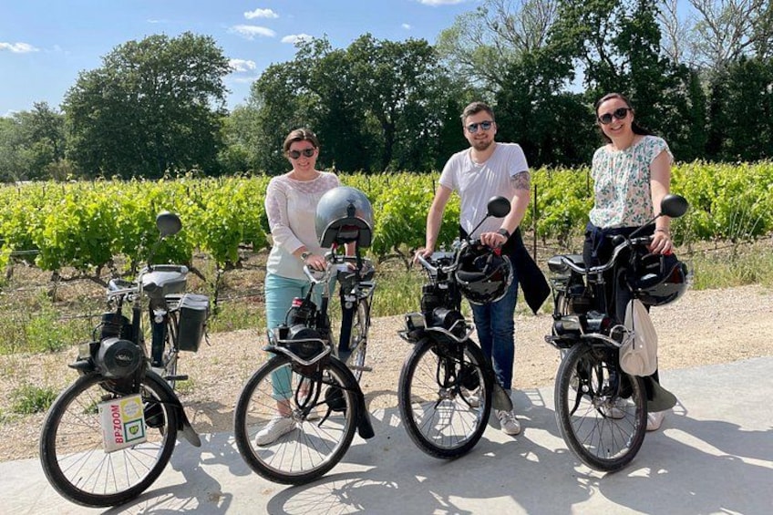 Three people on bicycles in a vineyard. 3