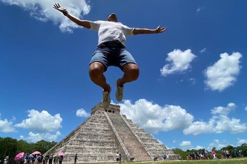 A person jumping in front of a pyramid with a clear sky. 2