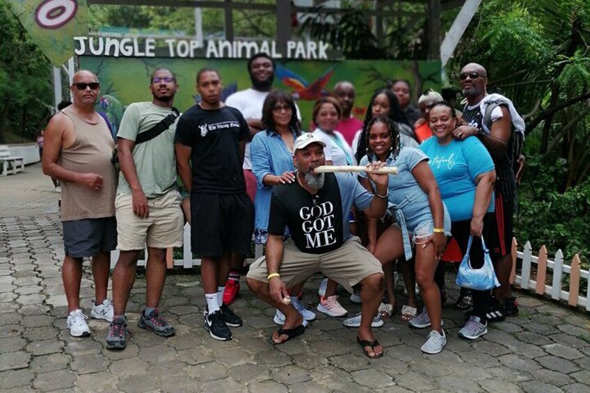 A group of people posing in front of a sign for Jungle Top Animal Park. 2