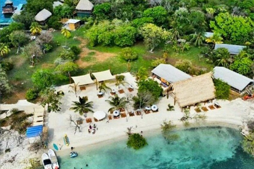 Un complexe hôtelier tropical doté de bungalows sur la plage, de chaises longues et bordé d’une mer turquoise aux eaux cristallines. 5