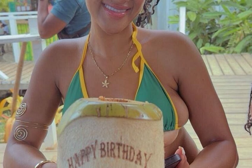 A person holding a birthday cake with 'HAPPY BIRTHDAY' written on it. 4