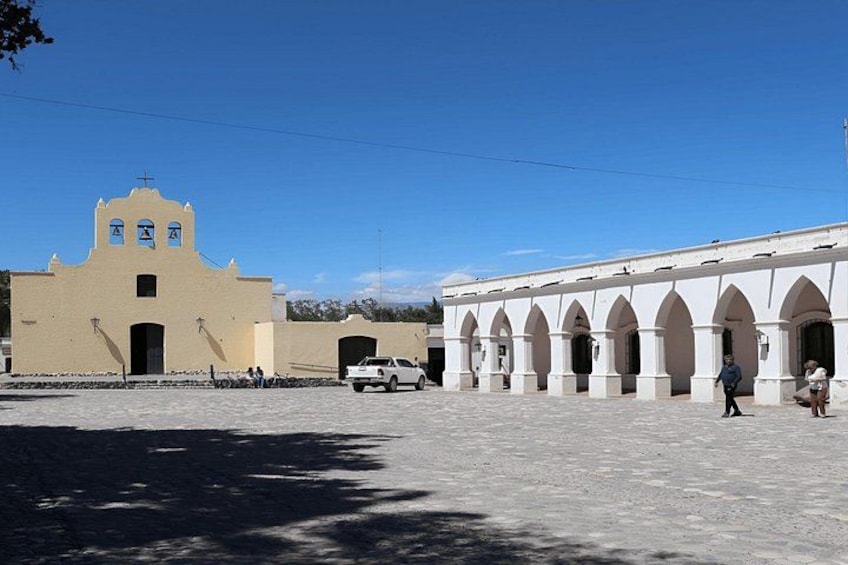 A church with a bell tower and a courtyard with arches. 2