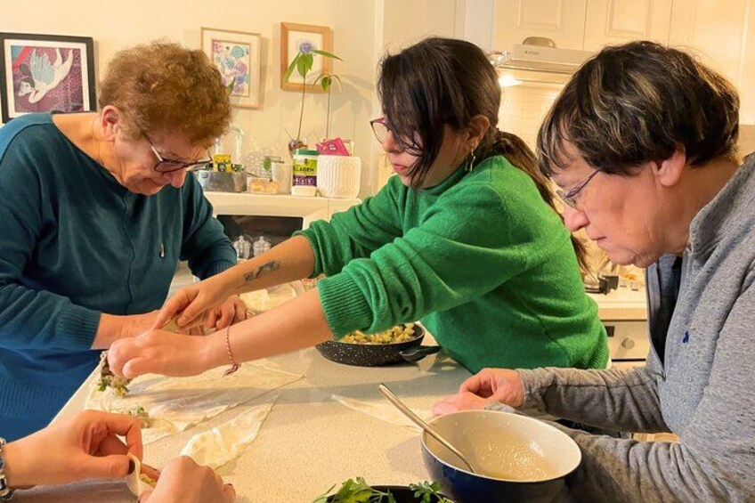 Tre persone che preparano del cibo, con una ciotola di zuppa e un piatto da tavola. 2