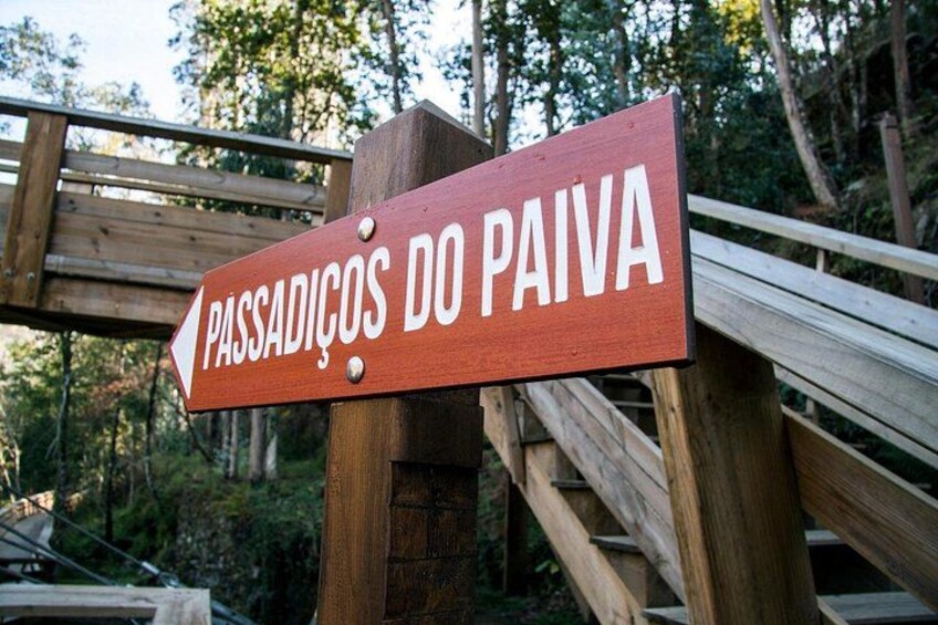 A wooden sign with the text 'PASSADIÇOS DO PAIVA' pointing to the left. 5