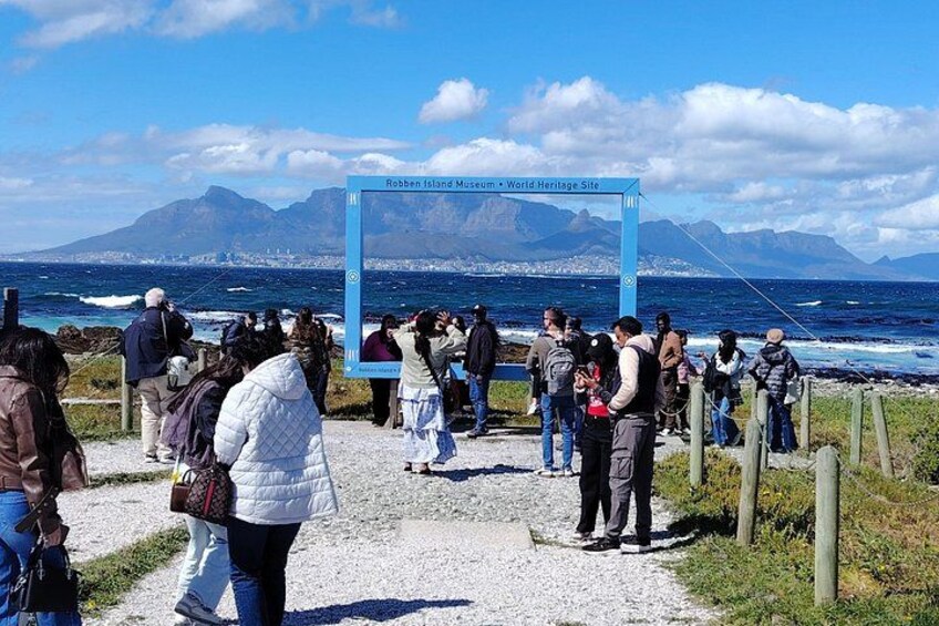 Eine Menschenmenge vor dem Robben-Insel-Museum, im Hintergrund Meer und Berge. 3