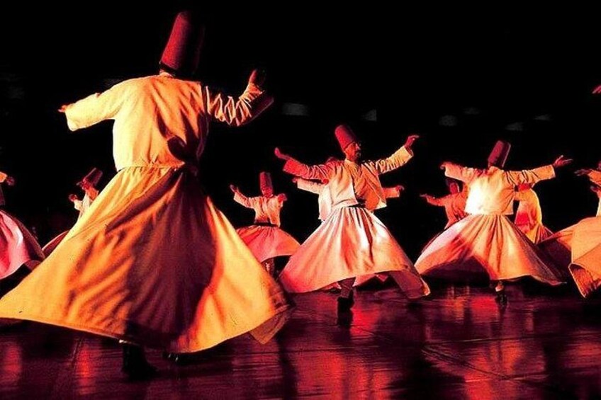 A group of dancers in traditional costumes performing on a stage. 3