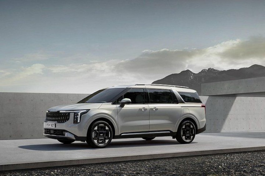 Een witte SUV geparkeerd op een betonnen oppervlak met bergen op de achtergrond. 2