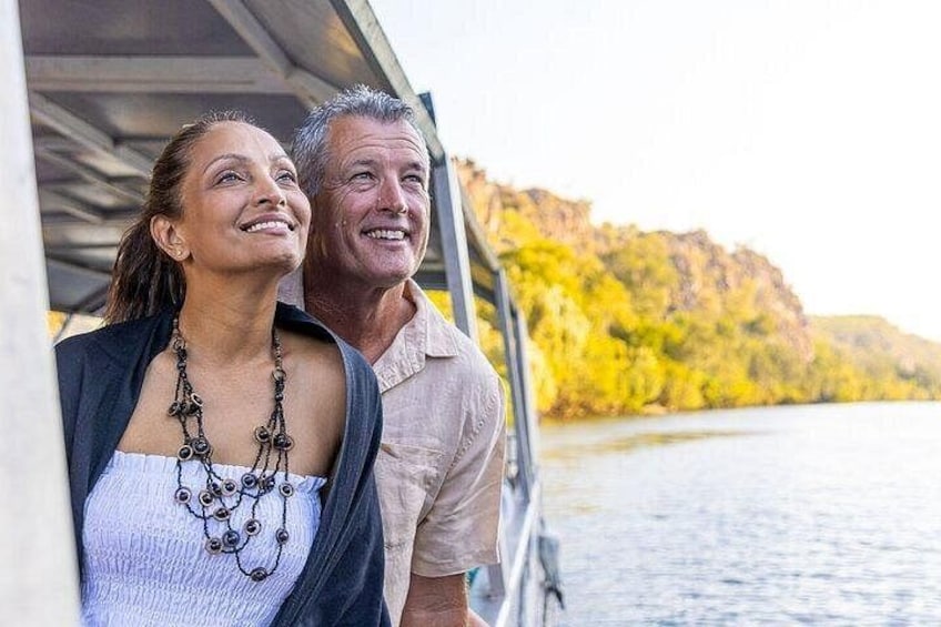 A couple on a boat with autumn foliage in the background. 4