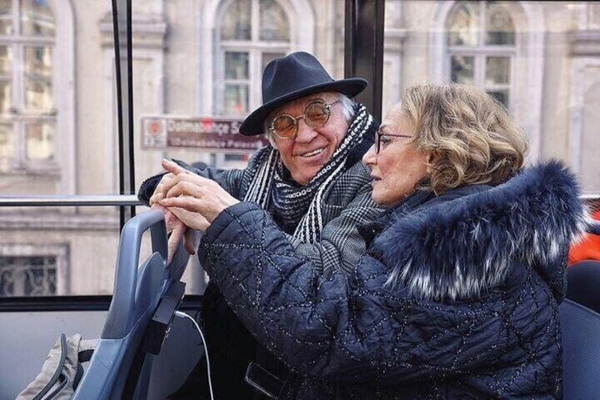 Two people sitting on a bus, one wearing a fur-lined coat. 5