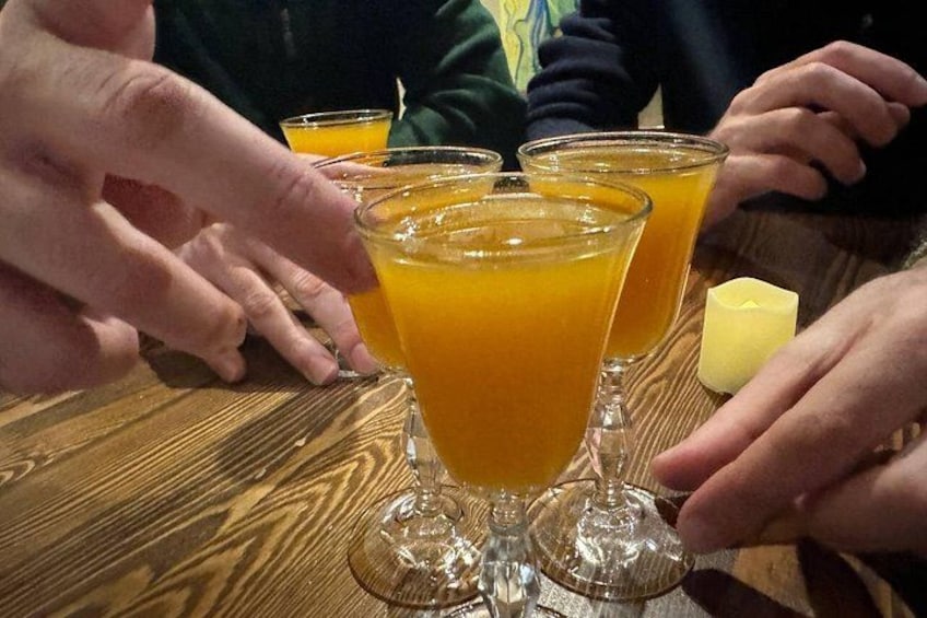 A wooden table with three glasses of orange juice and a small yellow object. 1