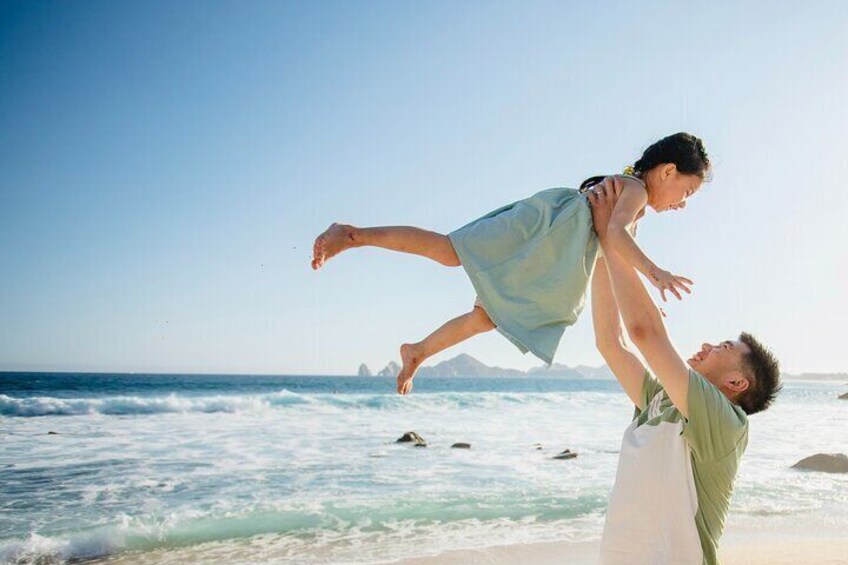A person carrying a child on their shoulders at the beach. 5