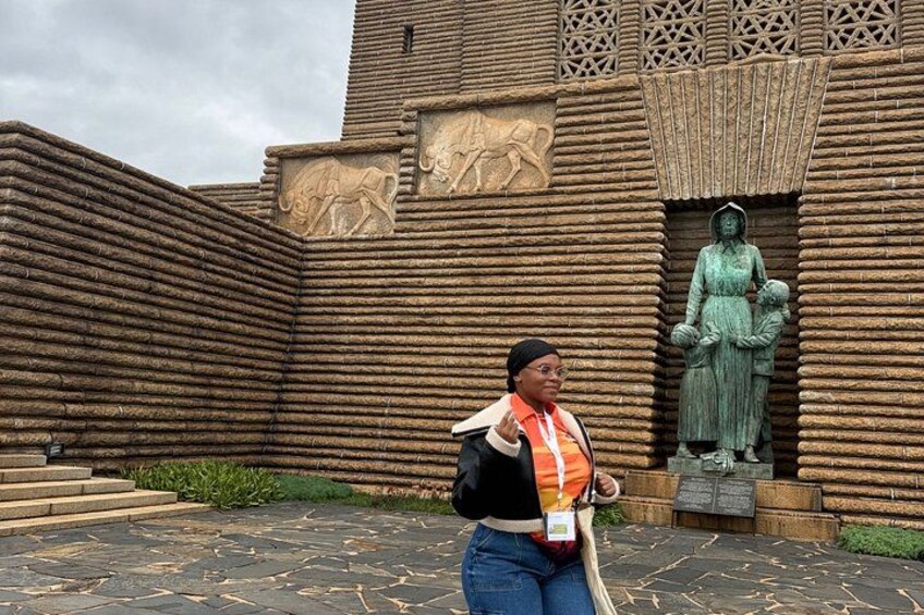 A person standing in front of a building with a statue and a relief sculpture. 2