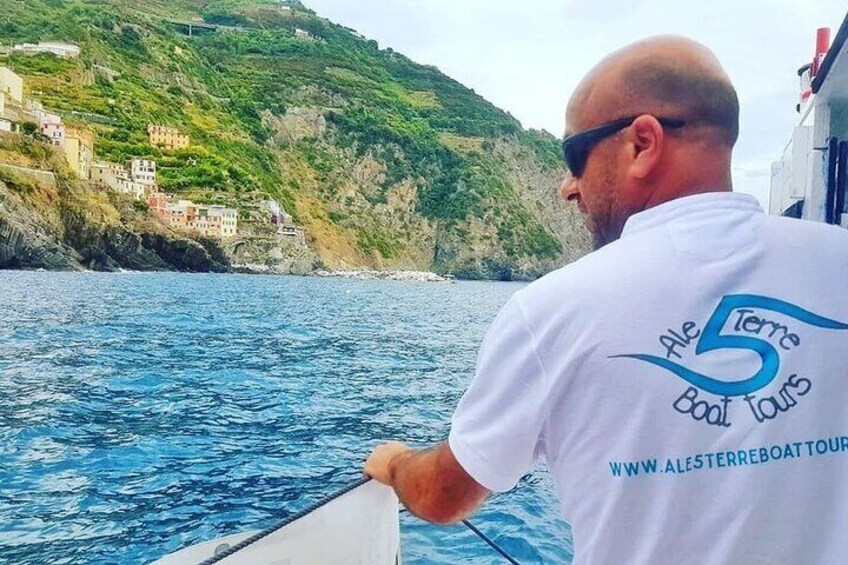 A man on a boat wearing a white t-shirt with the text "5 Terms Cool Tours" and a website address. 1