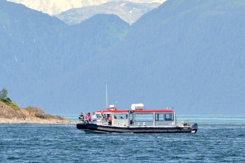 Una barca su acque calme con montagne sullo sfondo. 2