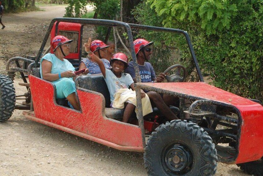 A red off-road vehicle with four passengers wearing helmets. 2