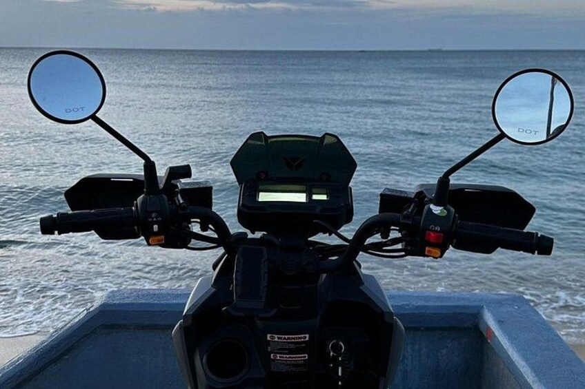 En motorcykel på ett båtdäck med utsikt över havet. 5