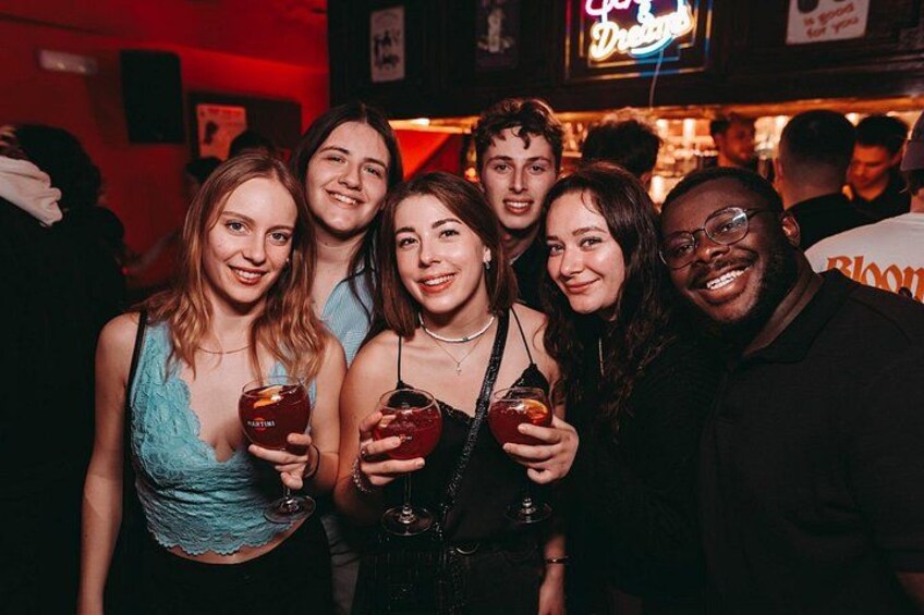 Eine Gruppe von Personen in einer Bar, die Getränke halten. 4