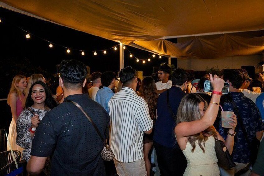Un grupo de personas reunidas bajo una carpa en un evento. 2