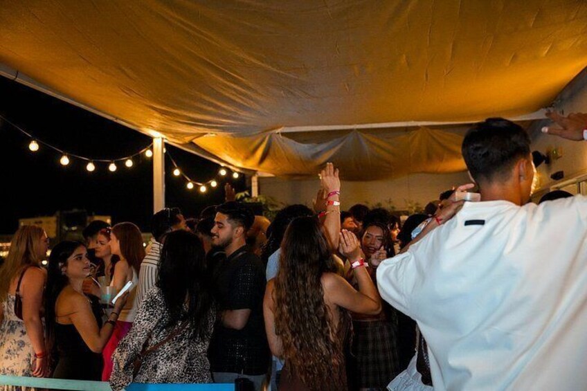 Un grupo de personas bailando bajo una carpa en un evento. 5
